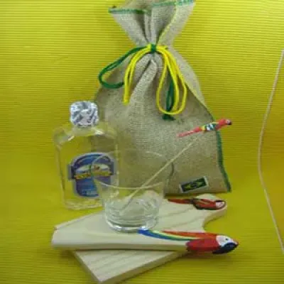 Kit caipirinha personalizado, composto por tábua, copo, batedor, mexedor e uma garrafa de bebida em saco de juta com costura verde e amarela.Sua marca representada com o que o Brasil tem de melhor.