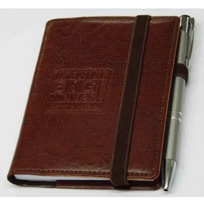 Moleskine personalizado em couro sintético (tamanho do bloco 8,5 x 12 cm), com espaço para caneta e personalização da logomarca em baixo relevo. Caneta opcional. Sua marca presente no dia a dia dos clientes.
