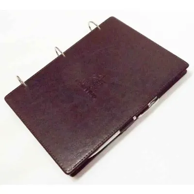 Porta bloco de anotações personalizado com argolas articuladas, em couro sintético, acabamento pespontado fechamento trava com caneta, 200 folhas.