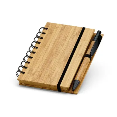 Caderno A6 espiral com capa dura em bambu, 70 folhas pautadas de papel reciclado e suporte para esferográfica. Esferográfica em bambu inclusa